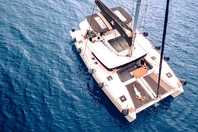 Half Day Premium Catamaran Cruise in Santorini including Oia - Red Beach: a quick swim beside rust-colored cliffs