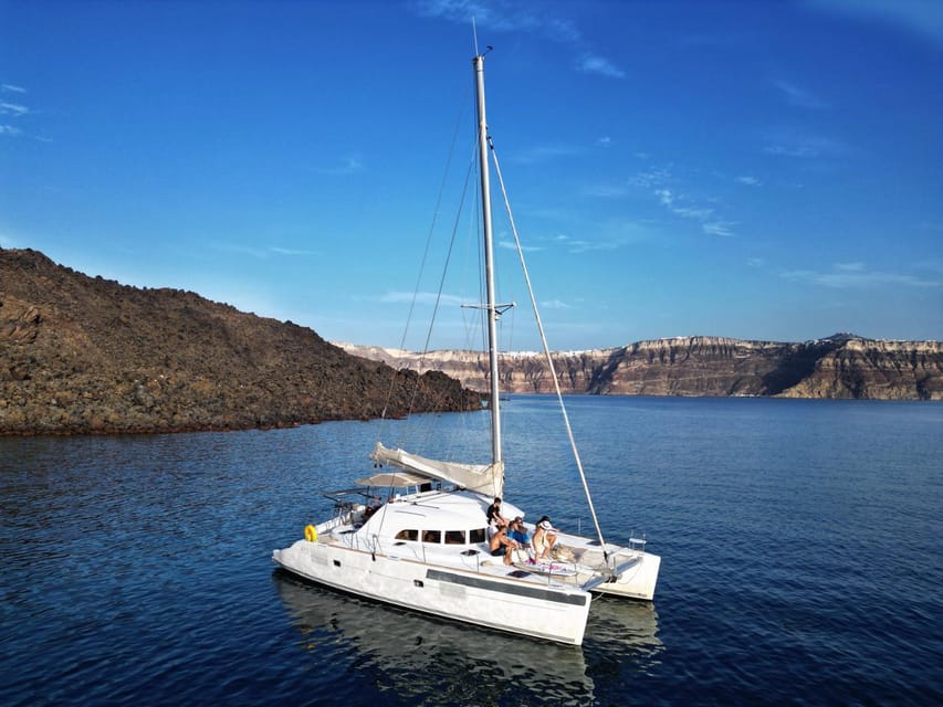 Santorini: Catamaran Cruise with Greek BBQ and Drinks - White Beach, sea caves, and the Akrotiri coast