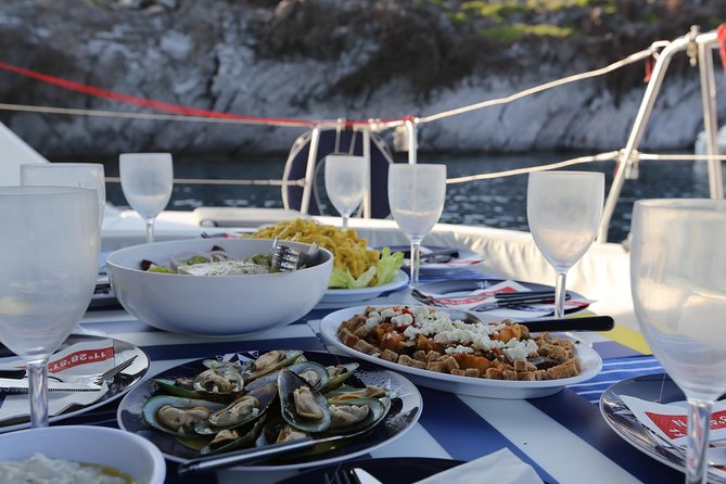 Santorini Half Day Catamaran Private Cruise incl. Meal, Drinks & Free Transport - The lighthouse and Aspronisi’s volcanic layers