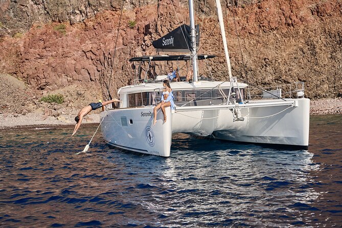 Santorini: Luxury Catamaran Cruise with Fresh Fish BBQ & Drinks - White Beach and the changing volcanic colors