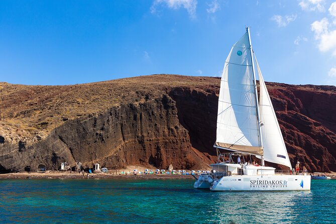 Santorini Private Catamaran Cruise with BBQ, Open Bar & Transfers - Red Beach: Santorini’s iron-colored opening scene