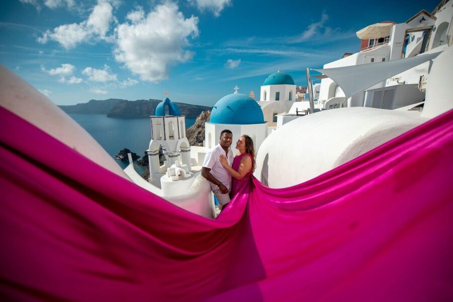 Santorini: Unique Flying Dress Photoshoot Experience - Oia and the blue-domed church backdrop